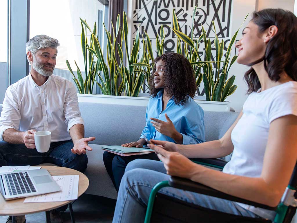 Foto de três colaboradores conversando sobre a aplicação de um teste de saúde mental na empresa.