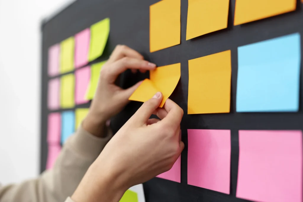 Foto de um painel com post-its coloridos colados, representando o uso da metologia Kanban de um planejamento empresarial com foco em integrar a avaliação de riscos psicossociais ao GRO (Gerenciamento de Riscos Ocupacionais).