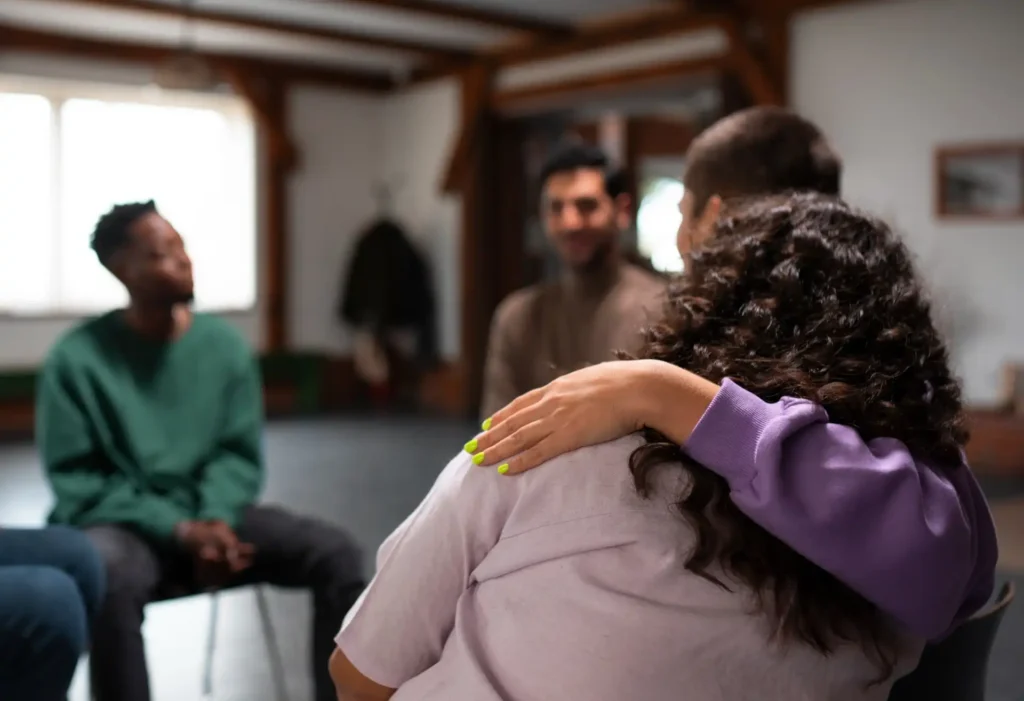 Foto de colaboradores reunidos e prestando apoio uns aos outros em uma das estratégias de sua organização para combater a cultura do estigma no ambiente corporativo.