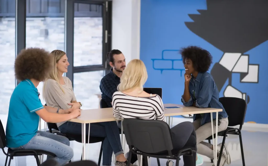 Foto de colaboradores em uma roda de conversa com sua liderança, avaliando pontos do ambiente de trabalho atual e demonstrando que pequenas ações geram grandes resultados para uma cultura organizacional positiva para todos.
