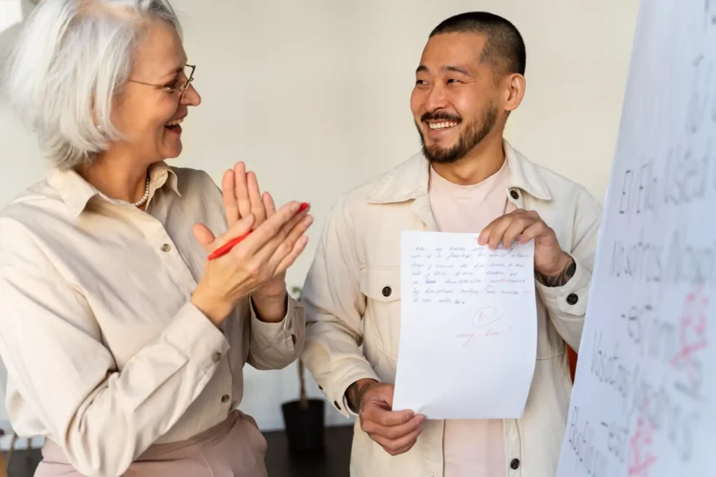 Foto de um colaborador e sua líder em momento de descontração após a conclusão de uma tarefa, mostrando como é importante a valorização e reconhecimento dos colaboradores para a cultura organizacional da empresa.