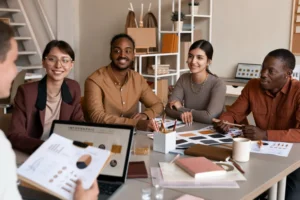 Foto de uma equipe diversa em reunião colaborativa em um escritório moderno, representando o employer branding e a cultura organizacional voltada para o engajamento e a reputação corporativa.